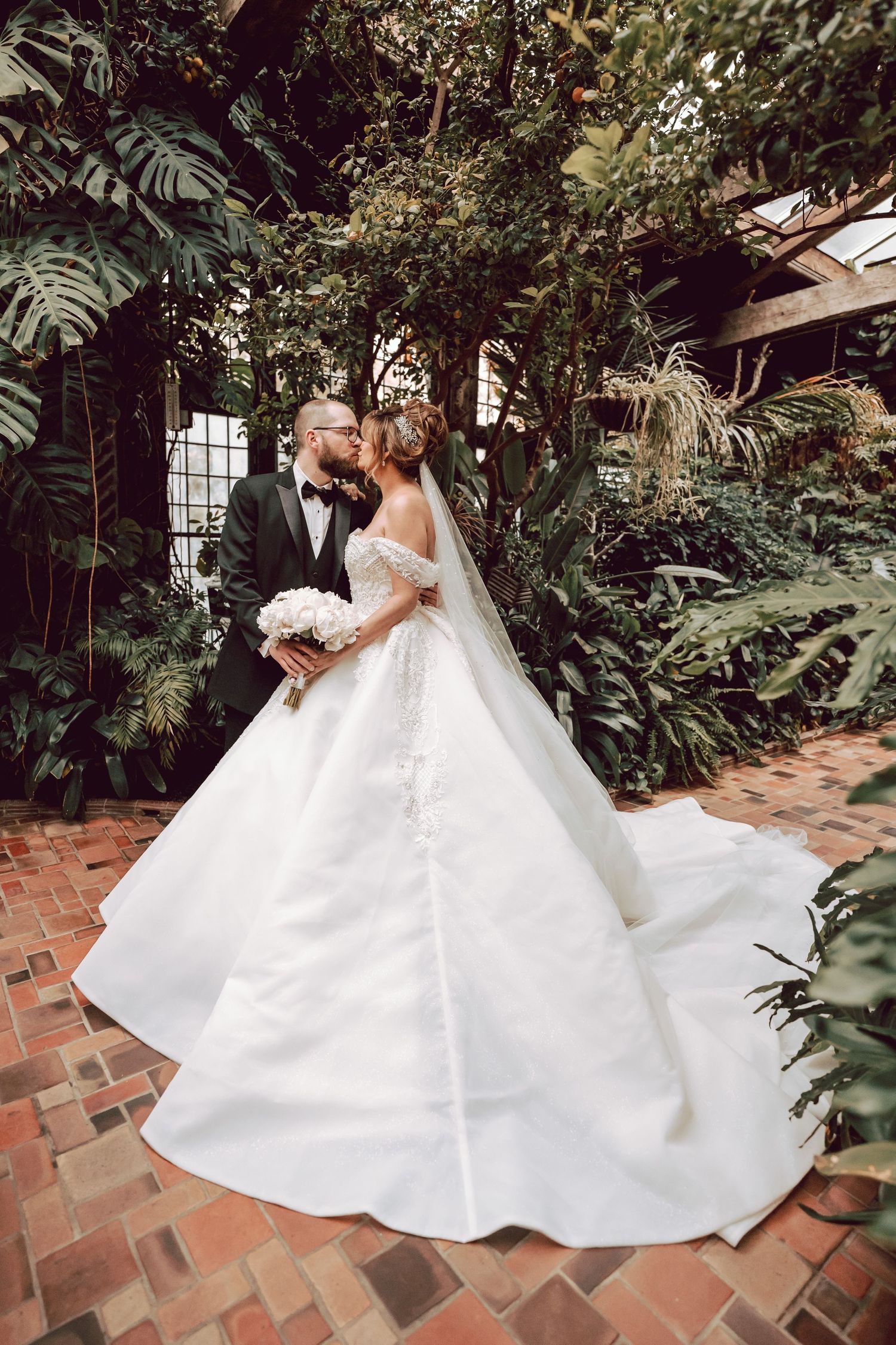 bride and groom kissing inside the green house at the Pleasantdale chateau