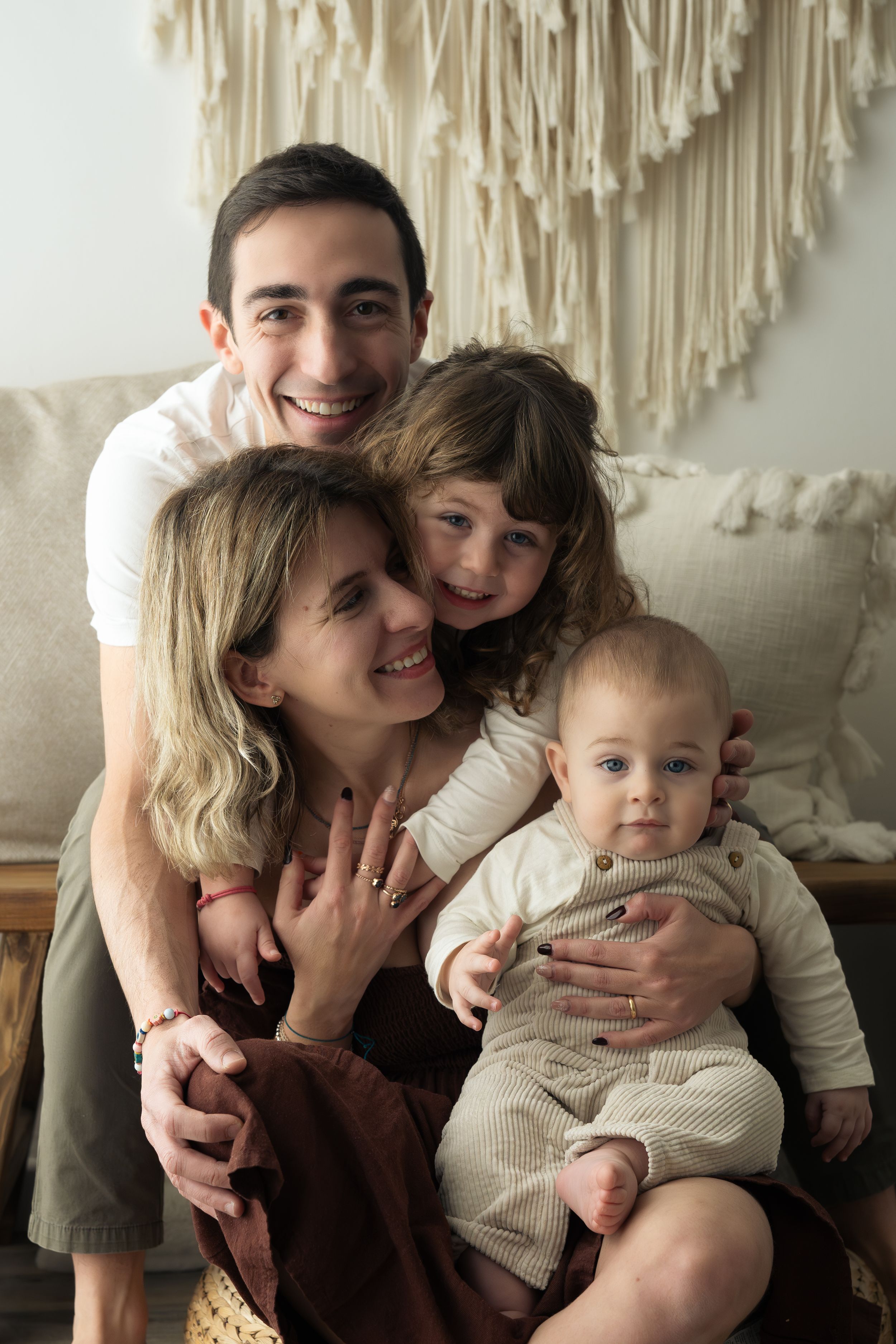 Famiglia di quattro persone che si guardano tra di loro e sorridono durante un servizio fotografico