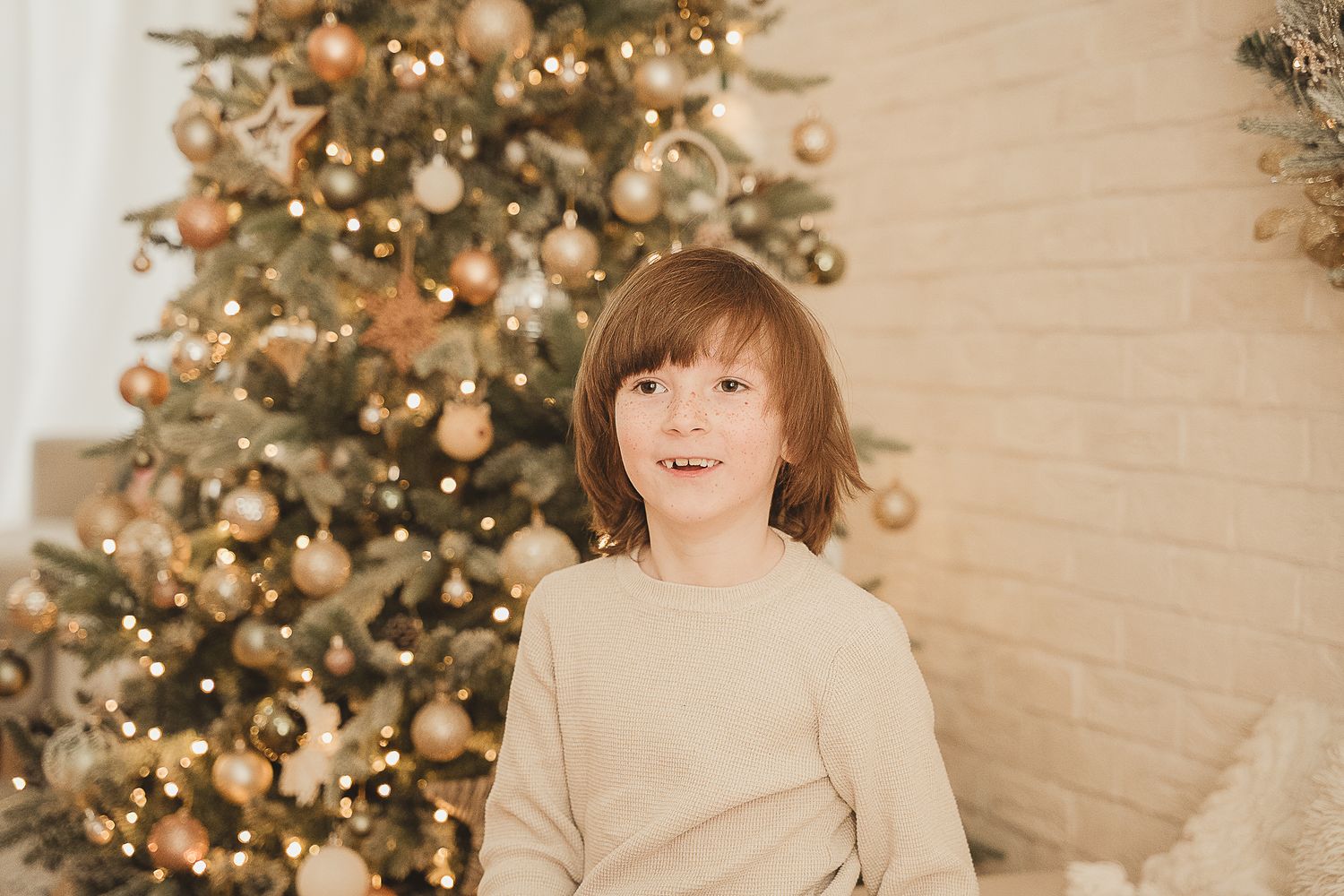 Cozy Christmas portrait against decorated tree and brick wall background. Maidenhead area