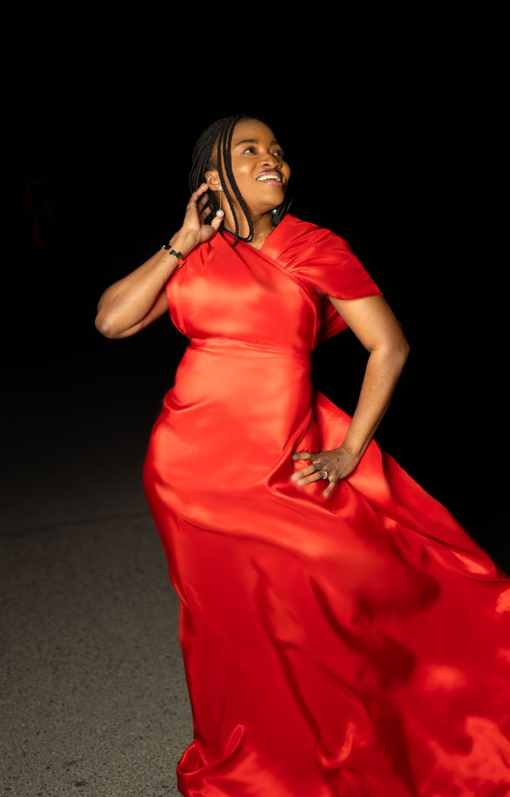 Person in flowing red dress posing dramatically against dark background in artistic photo sequence.