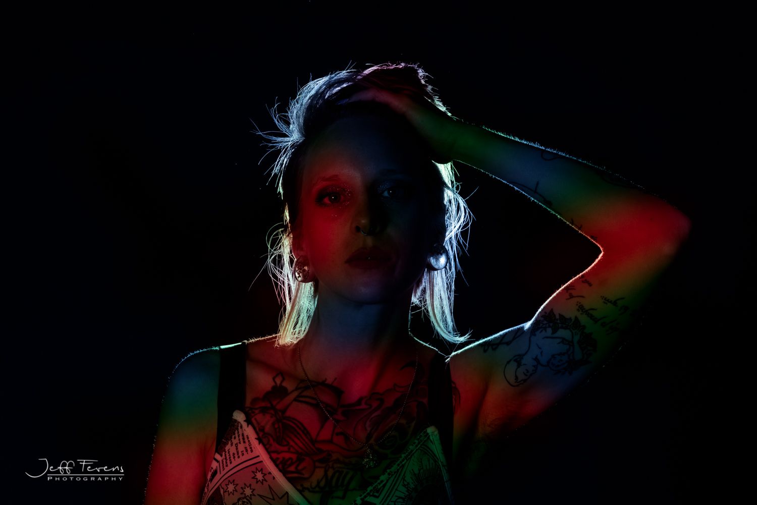 Creative portrait of a woman in studio with a backlit silhouette.