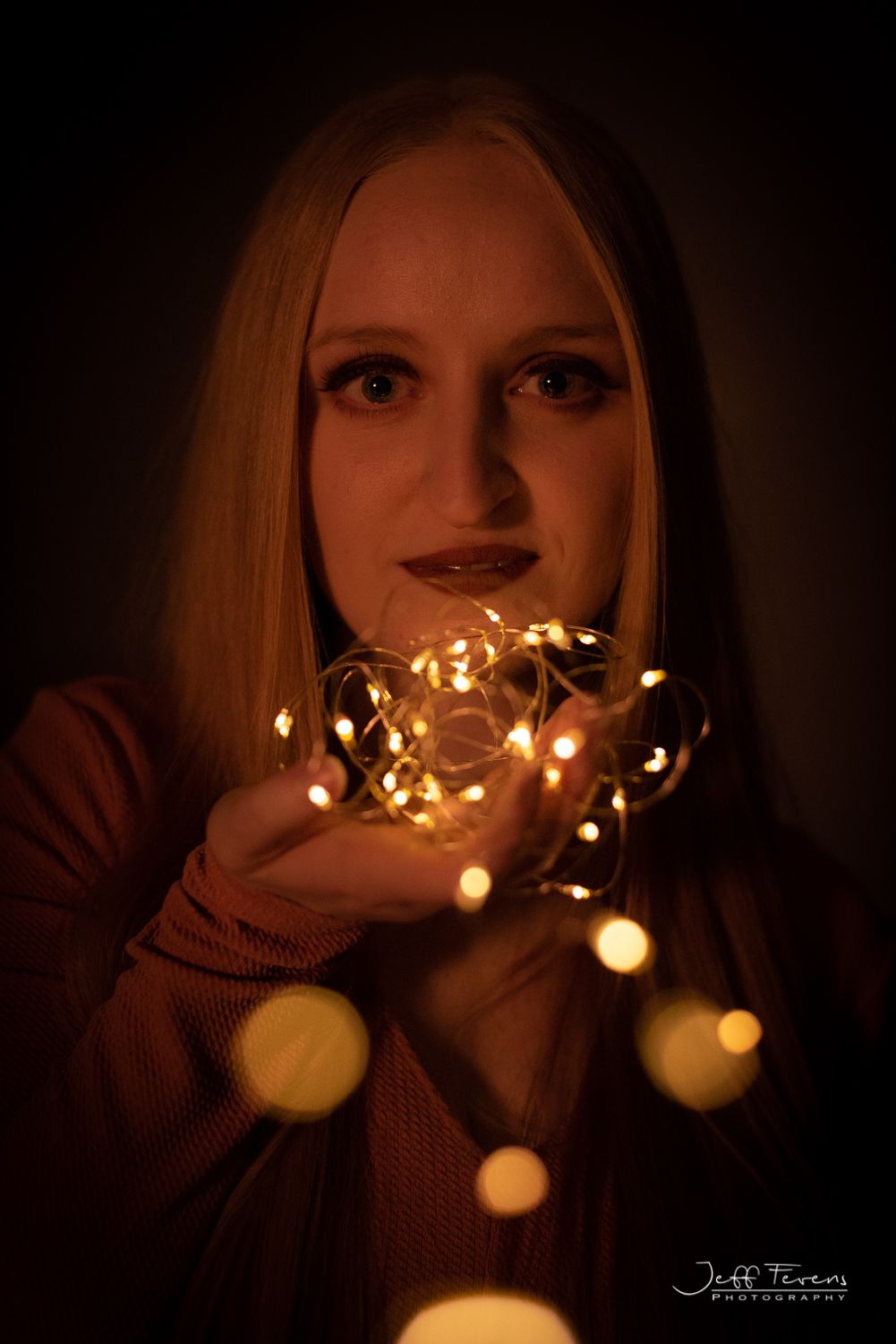 Creative portrait of a woman in studio with twinkle lights.