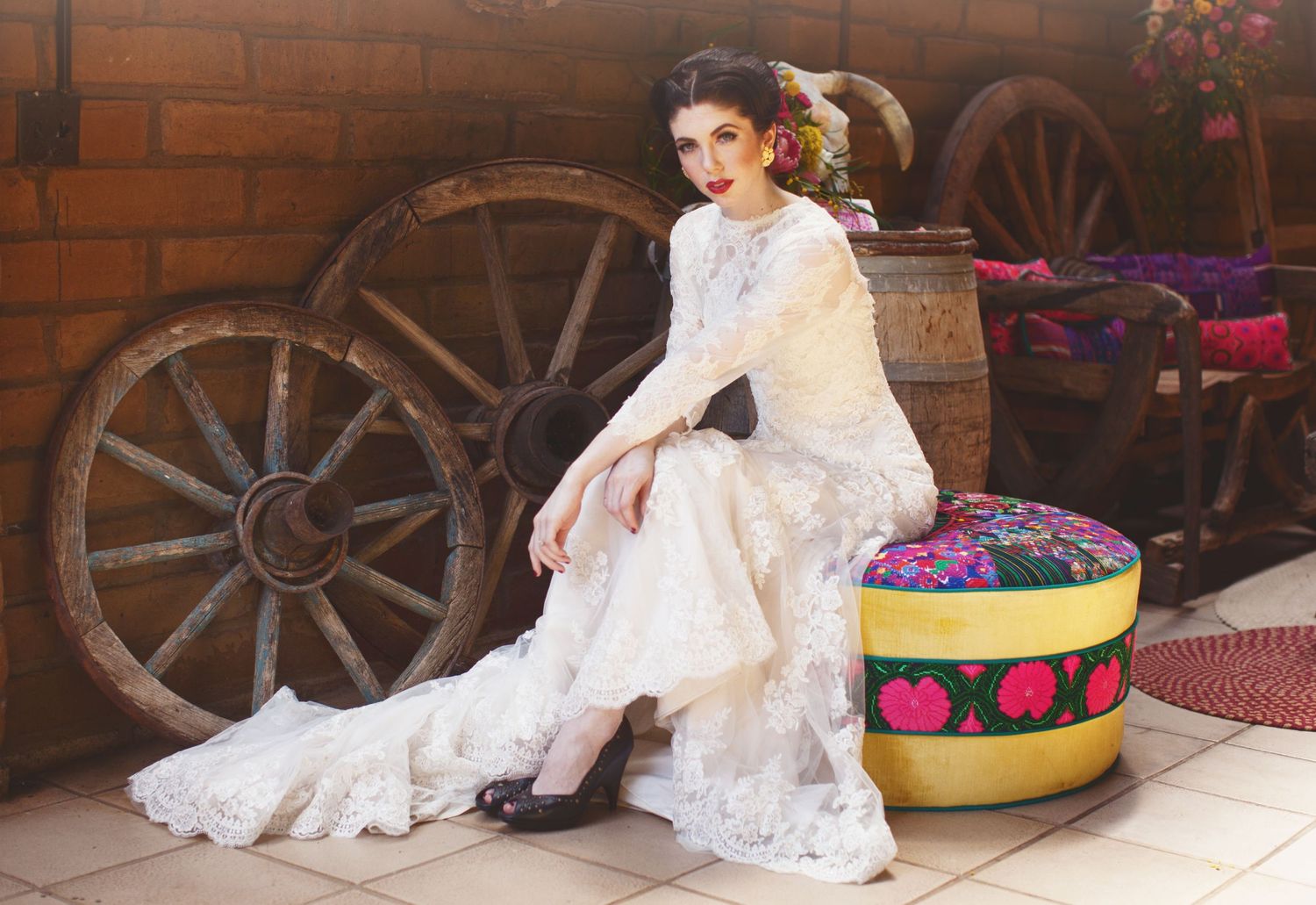 mexican bride sitting on a colorful couch in a southwestern barn
