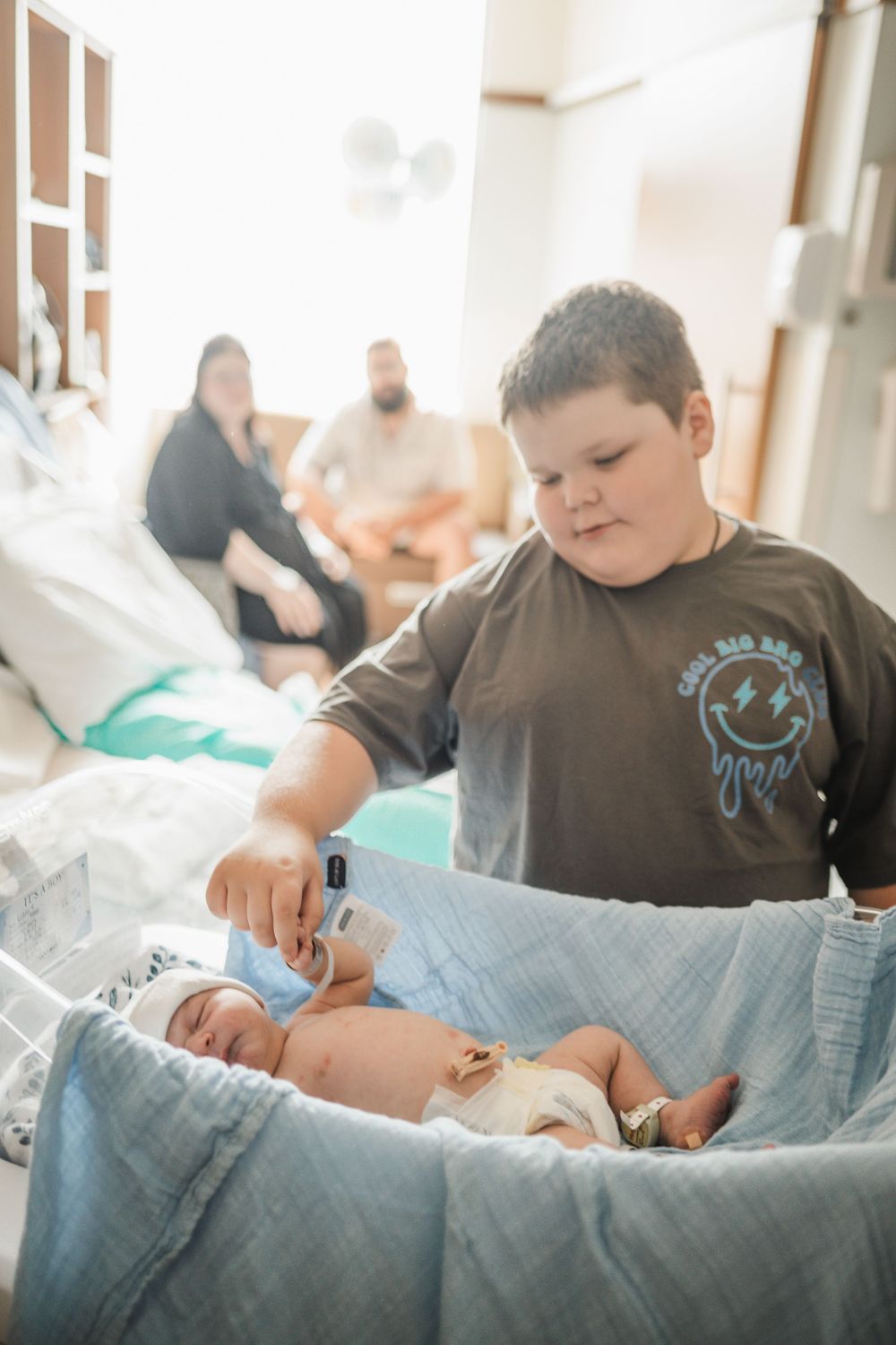 A series of four photos showing tender moments with a newborn baby in a blue blanket.
