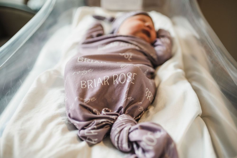 Close-up shot of a baby wrapped in white hospital blankets.