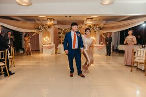 Wedding reception dance scene with couple dancing on illuminated ballroom floor.