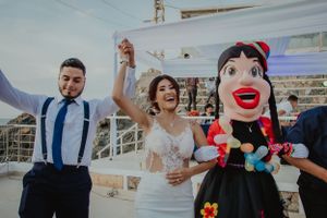 Wedding celebration with a playful puppet mascot on a boat deck.
