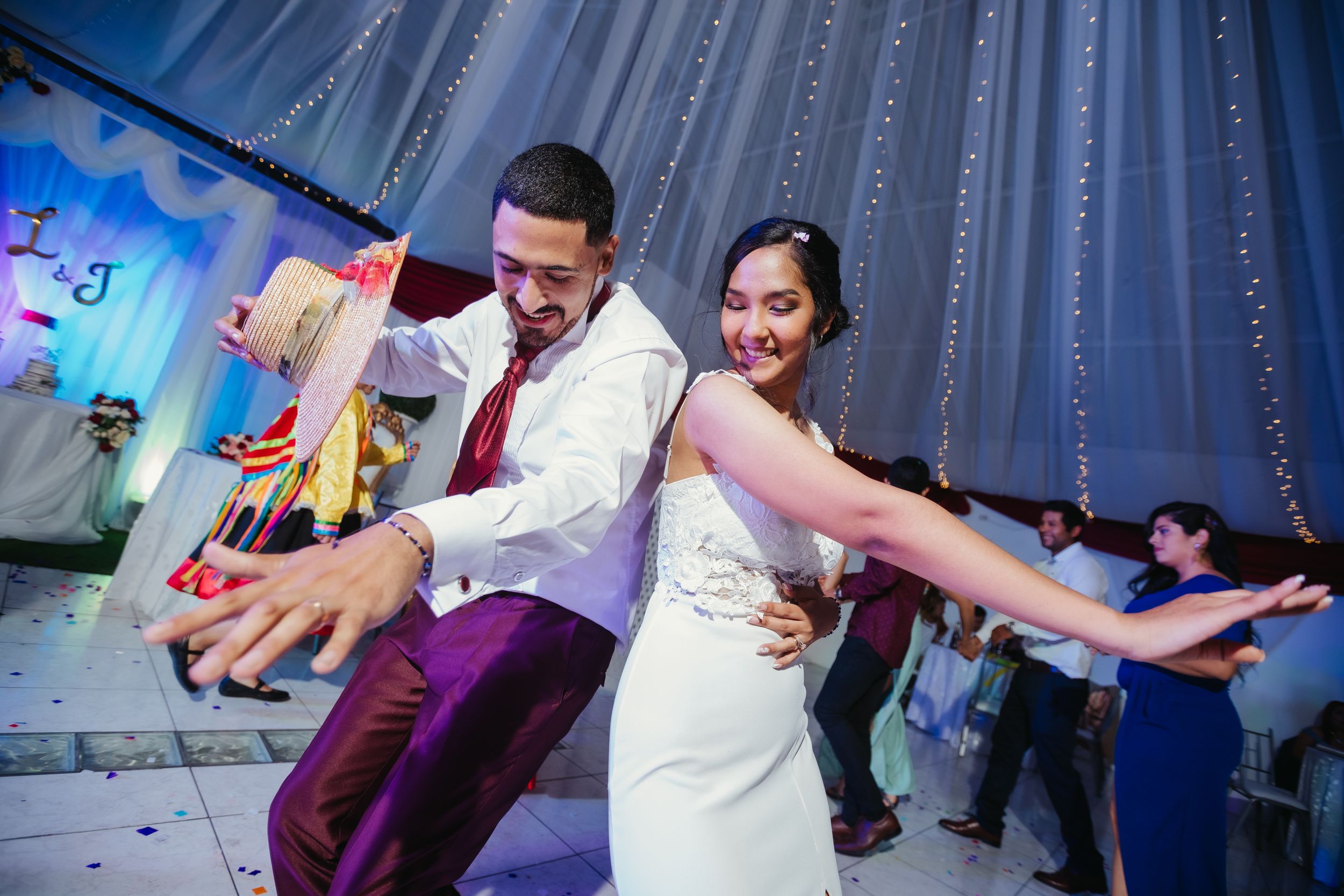Wedding couple performing synchronized dance moves during reception party.