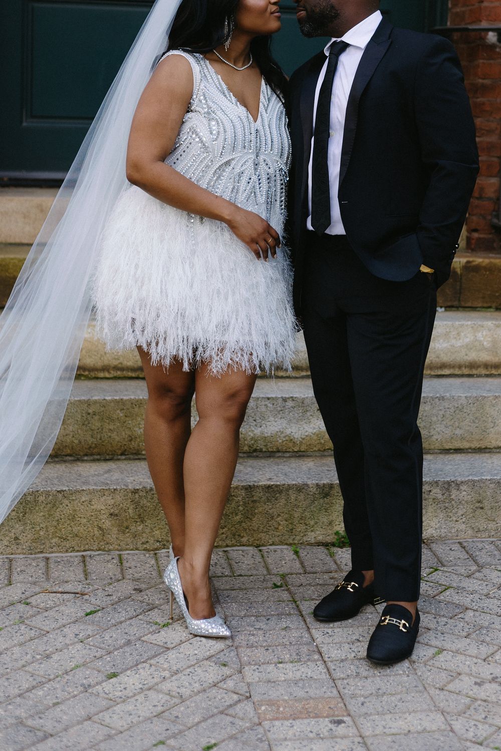 Woman in reception dress and man in suit share a glance.