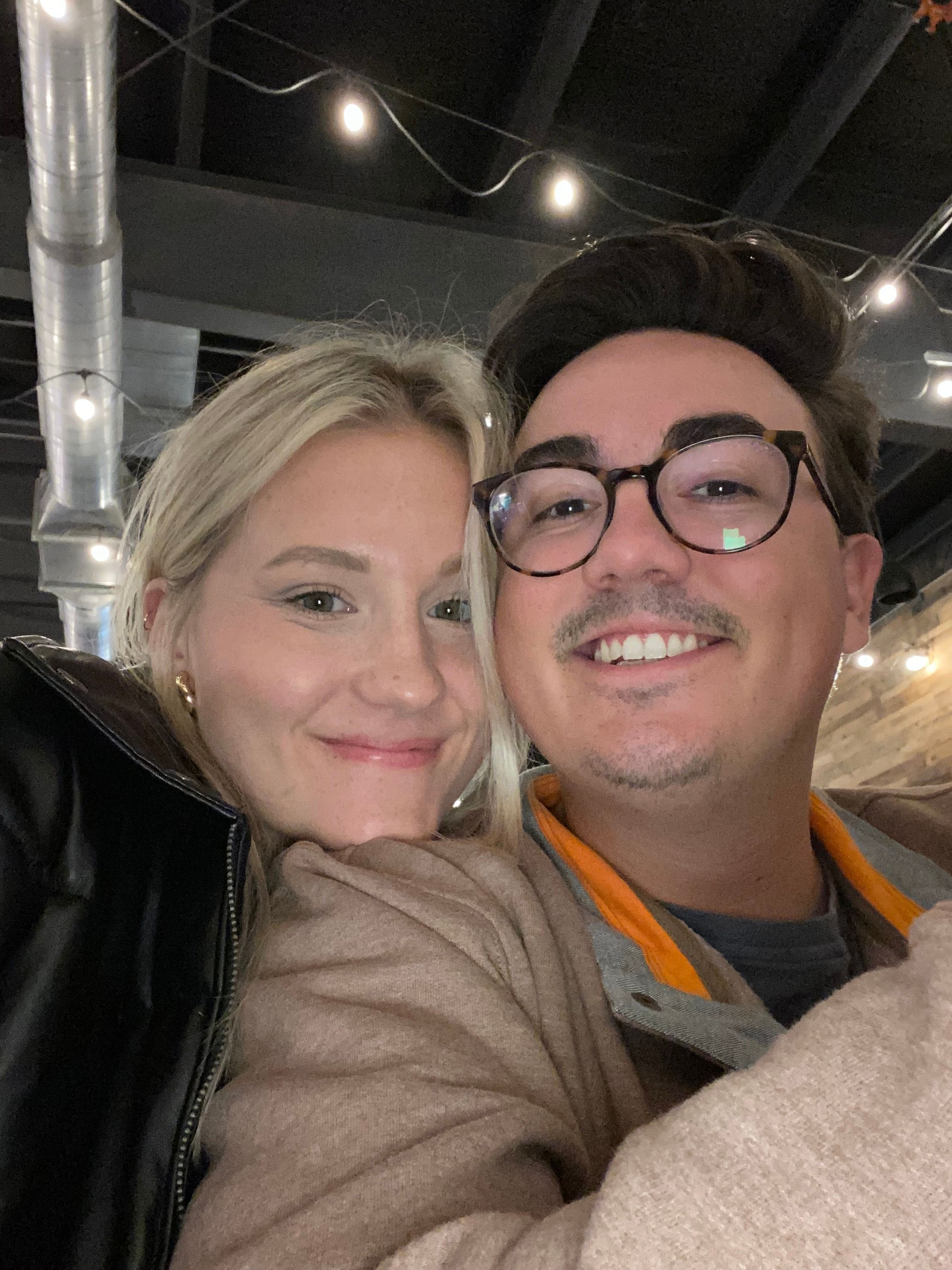 A selfie of a woman cuddled up on her husbands shoulder.