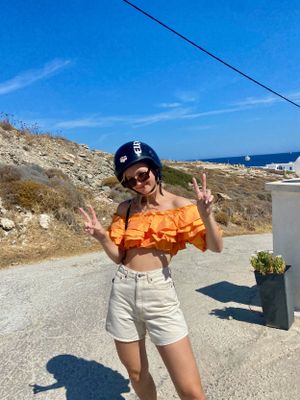 North Carolina Photographer poses for the camera while throwing double peace signs in Greece.