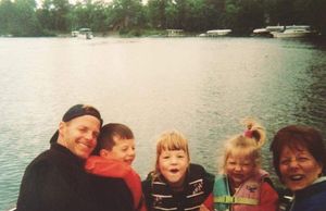 A film photo of a young family on the lake.