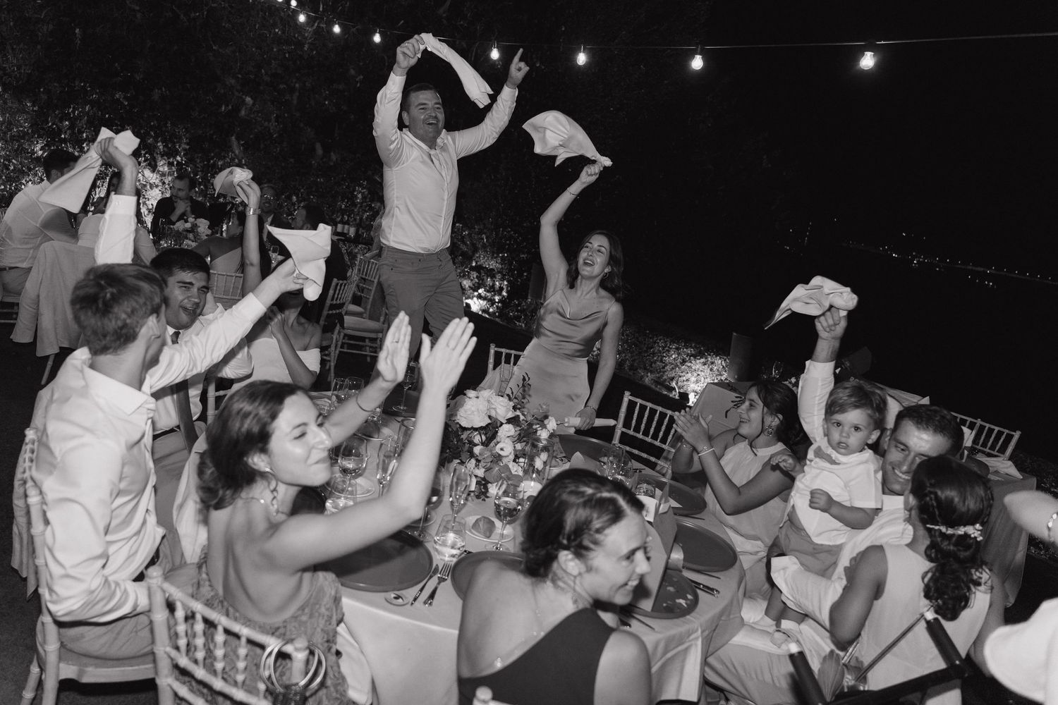 A joyful wedding moment captured with the couple holding a bouquet and laughing.