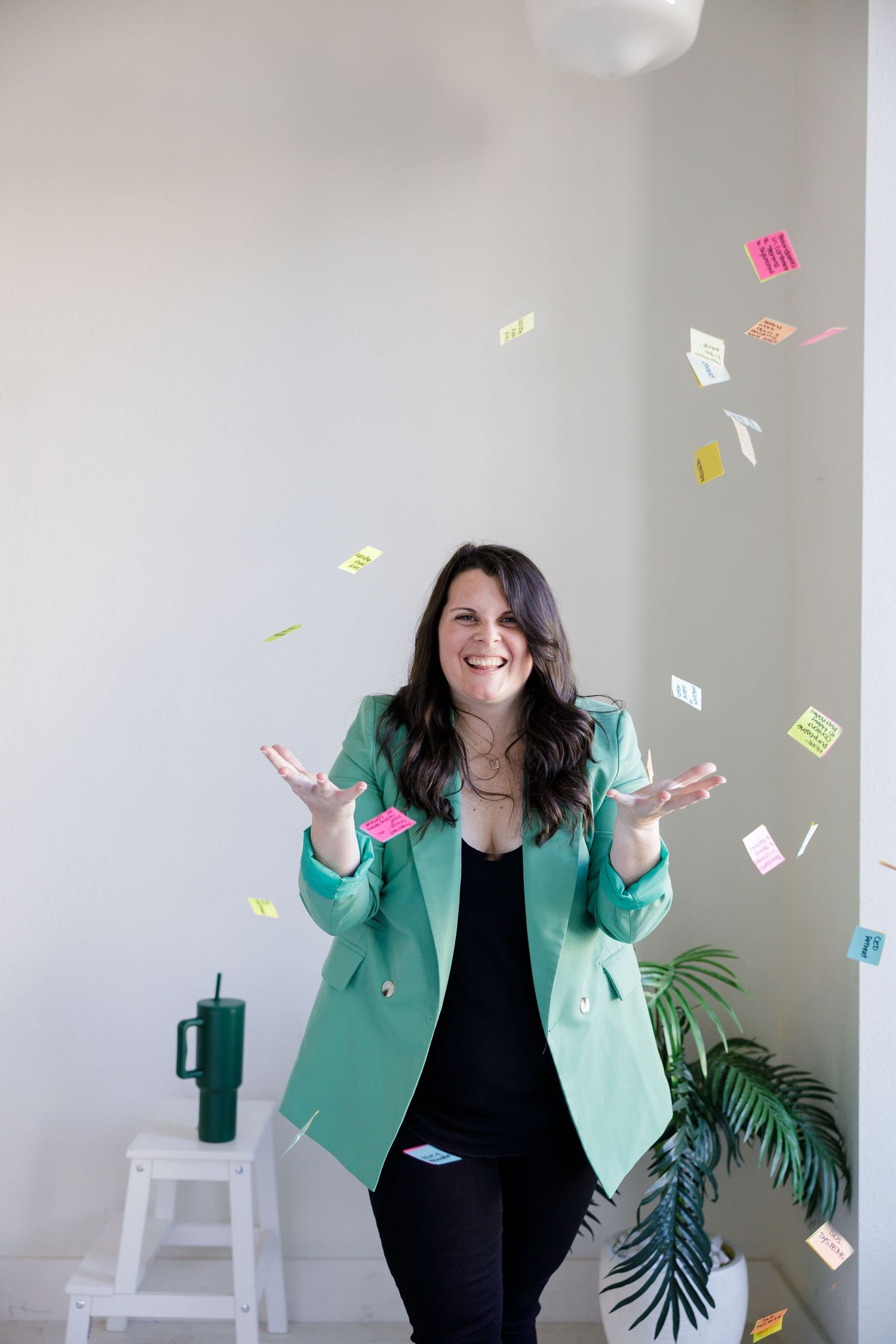 Woman burnout coach in Tacoma, WA GRLS Studio Personal branding photoshoot throwing postit notes in air laughing