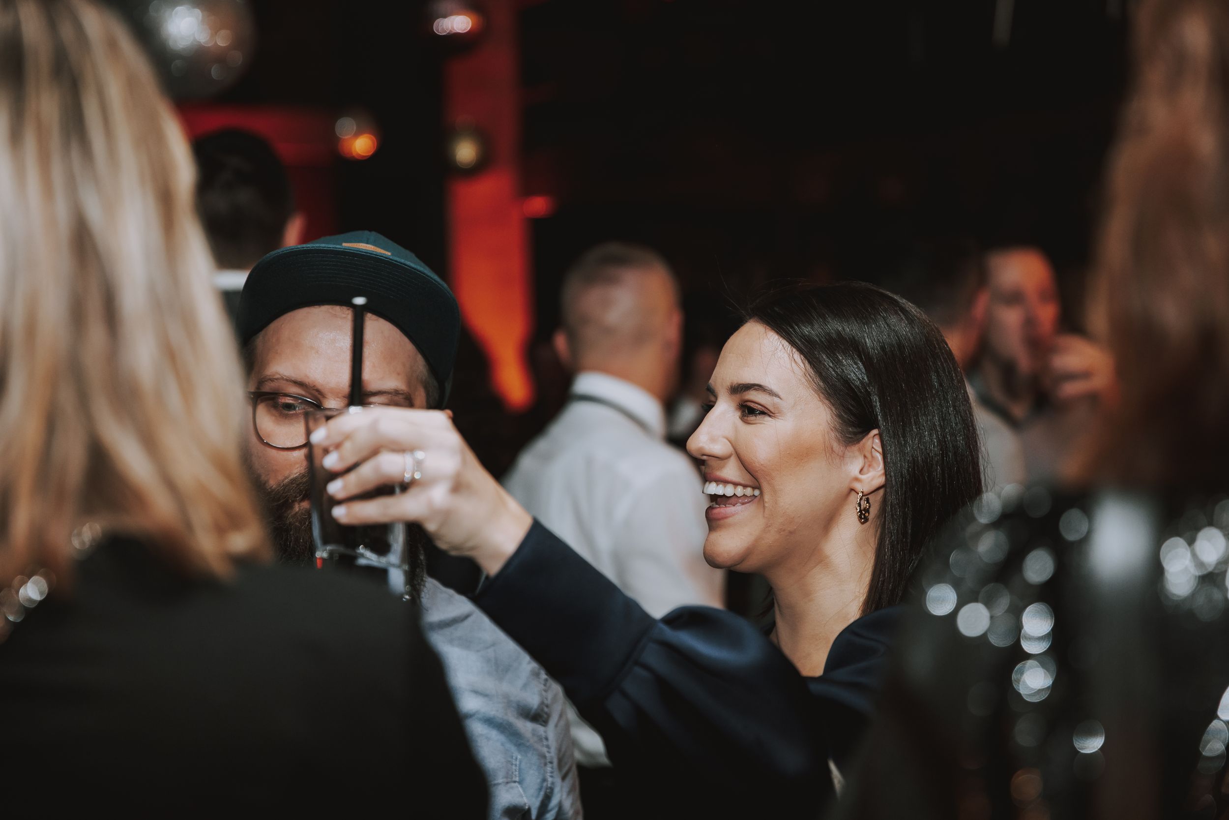 Friends sharing drinks and laughing at a social gathering.