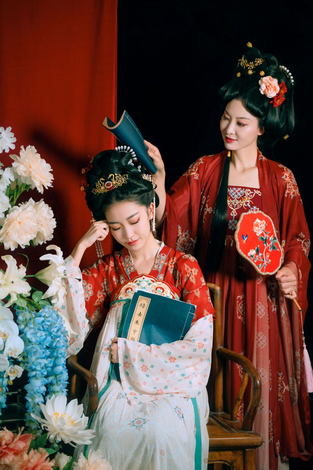 Elegant backlit studio portrait of mother and daughter in Tang Dynasty Hanfu on a swing among wisteria, by Imagine Image Studio.