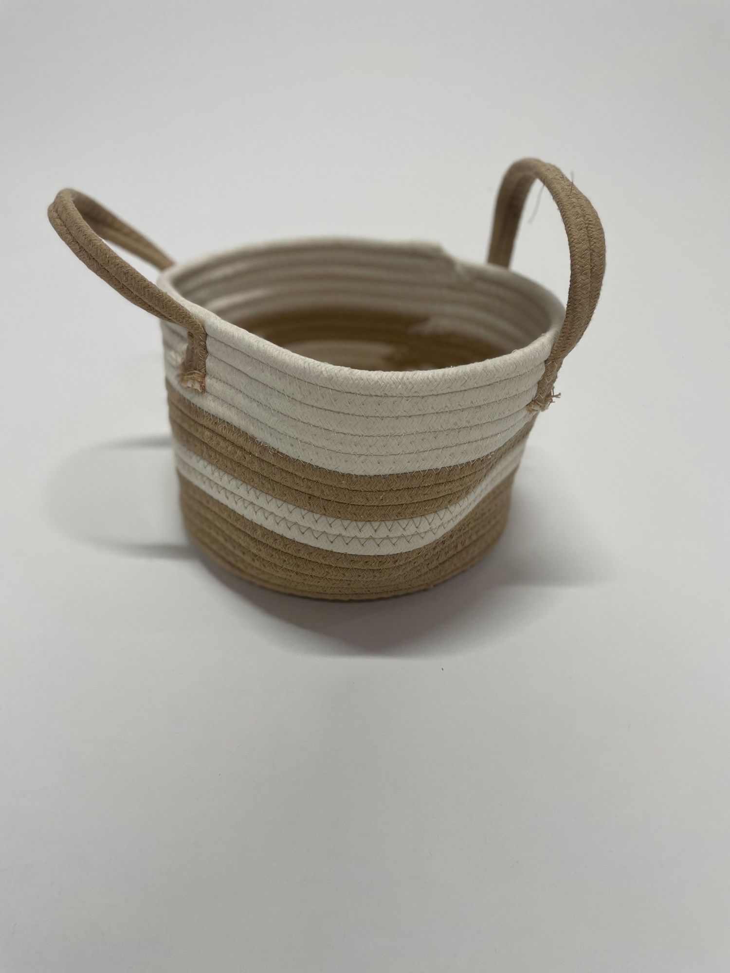 A curved rope-style handle or strap in beige and white tones.