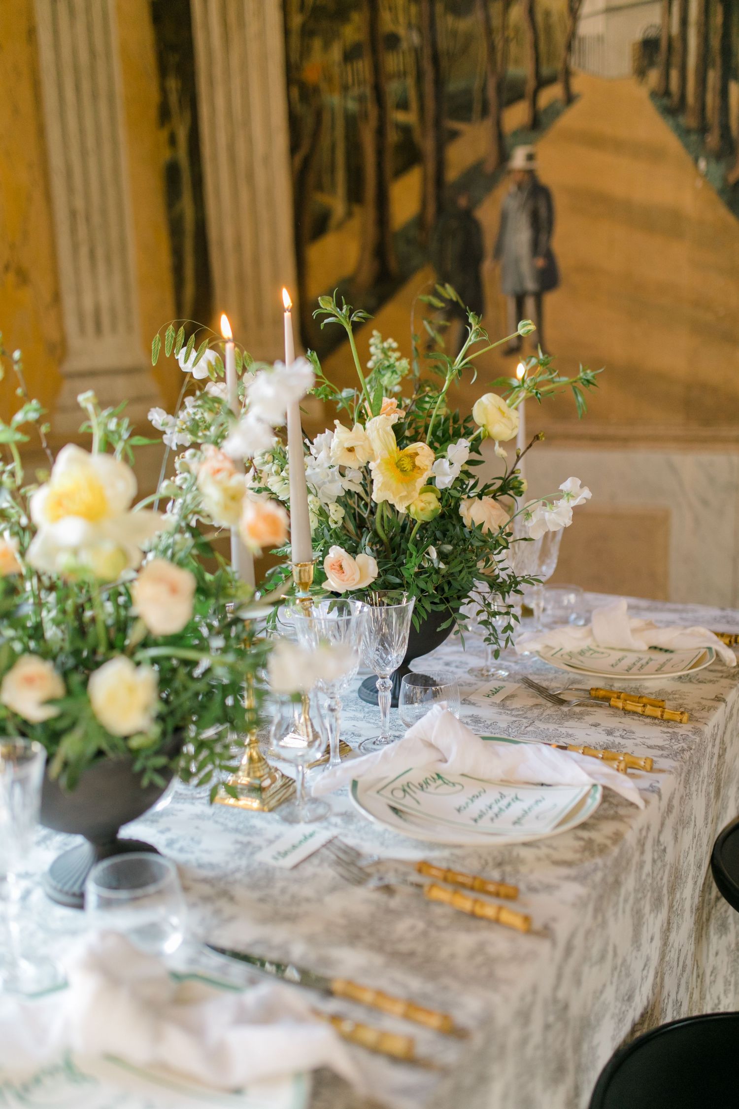 Elegant wedding reception room with crystal chandelier and white-covered chairs.