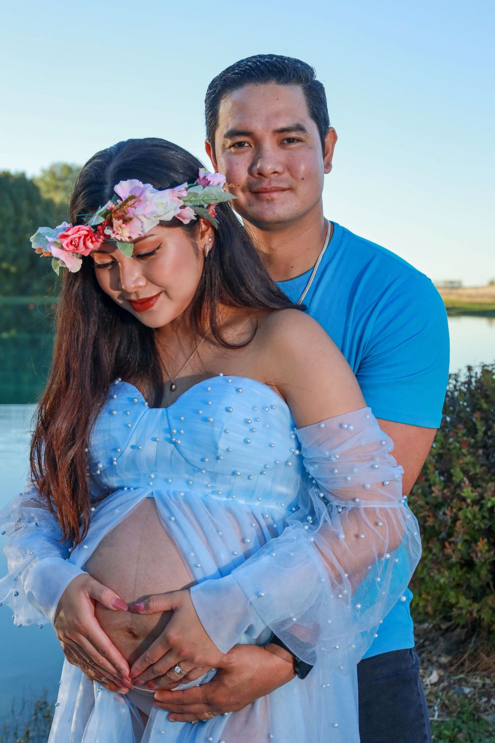Maternity picture of couple with lake in background.