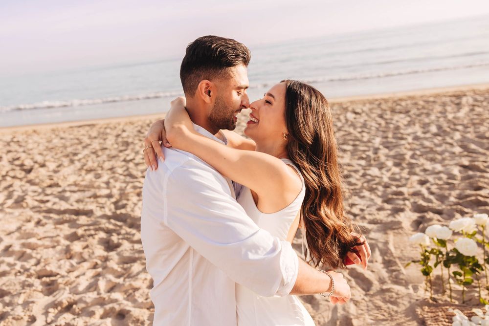 A romantic beach embrace during sunset with ocean waves in the background.