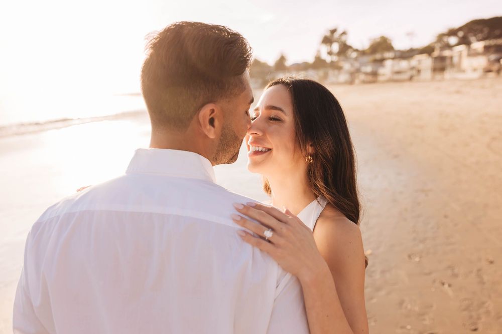 Couple sharing intimate moments during sunset beach photography session.