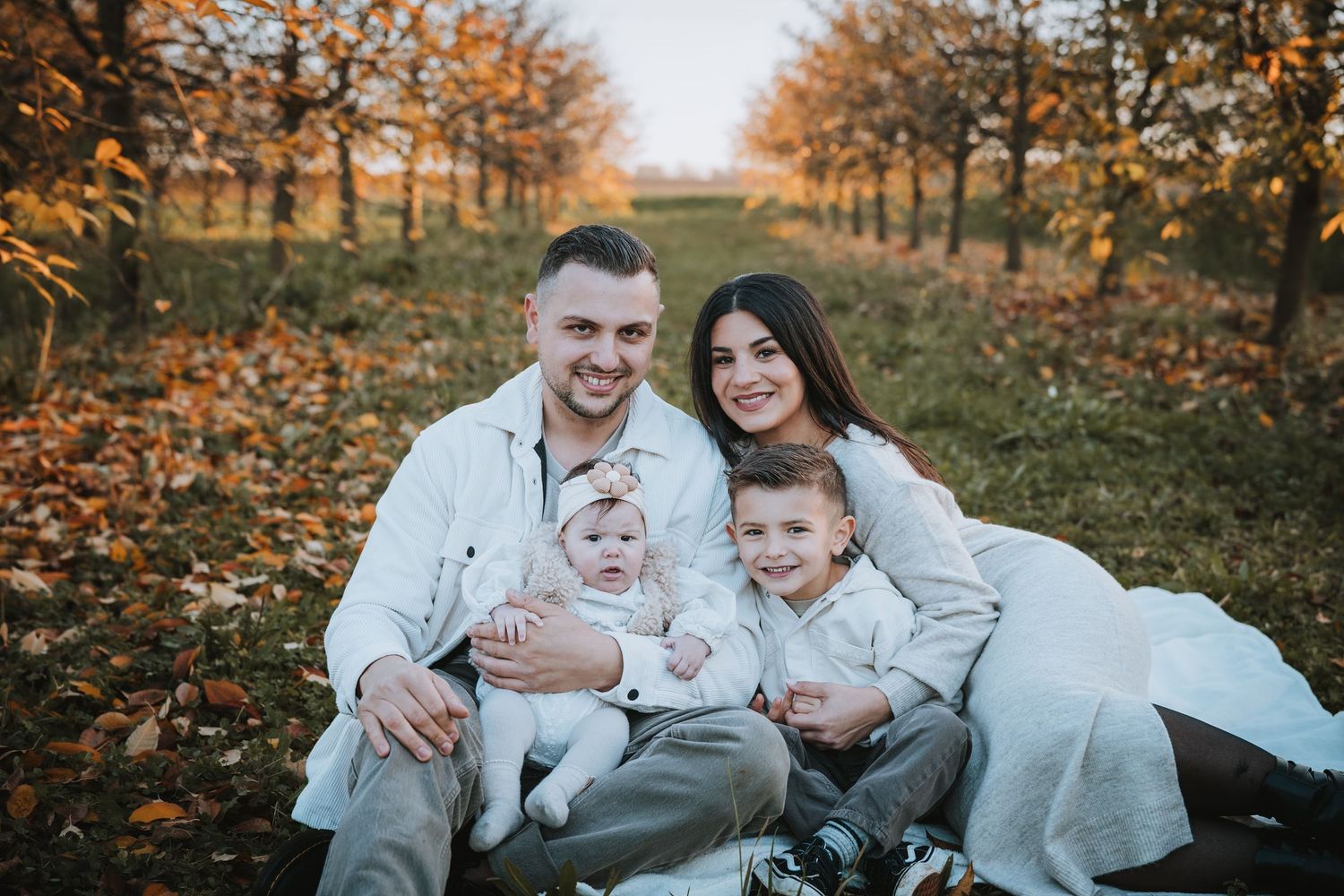 Family enjoying autumn day together in park with fall foliage.