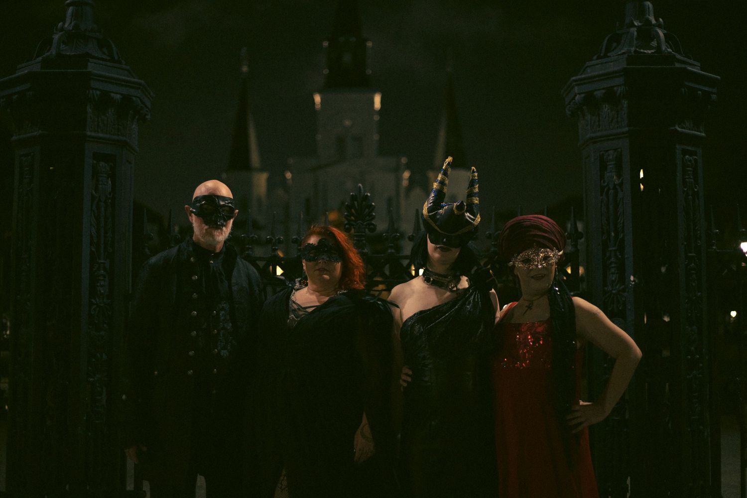 A dark and moody group photo with silhouettes against dramatic gothic architecture.  Image by Tesla Wolf Photography.