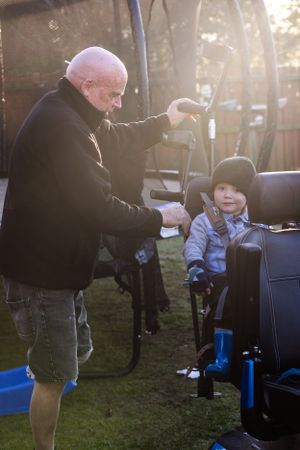 picture of a disabled man with grandchild  using mobility scooter at sunset