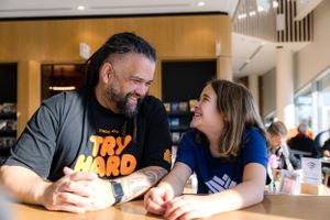Two people share a joyful moment while sitting at table indoors.