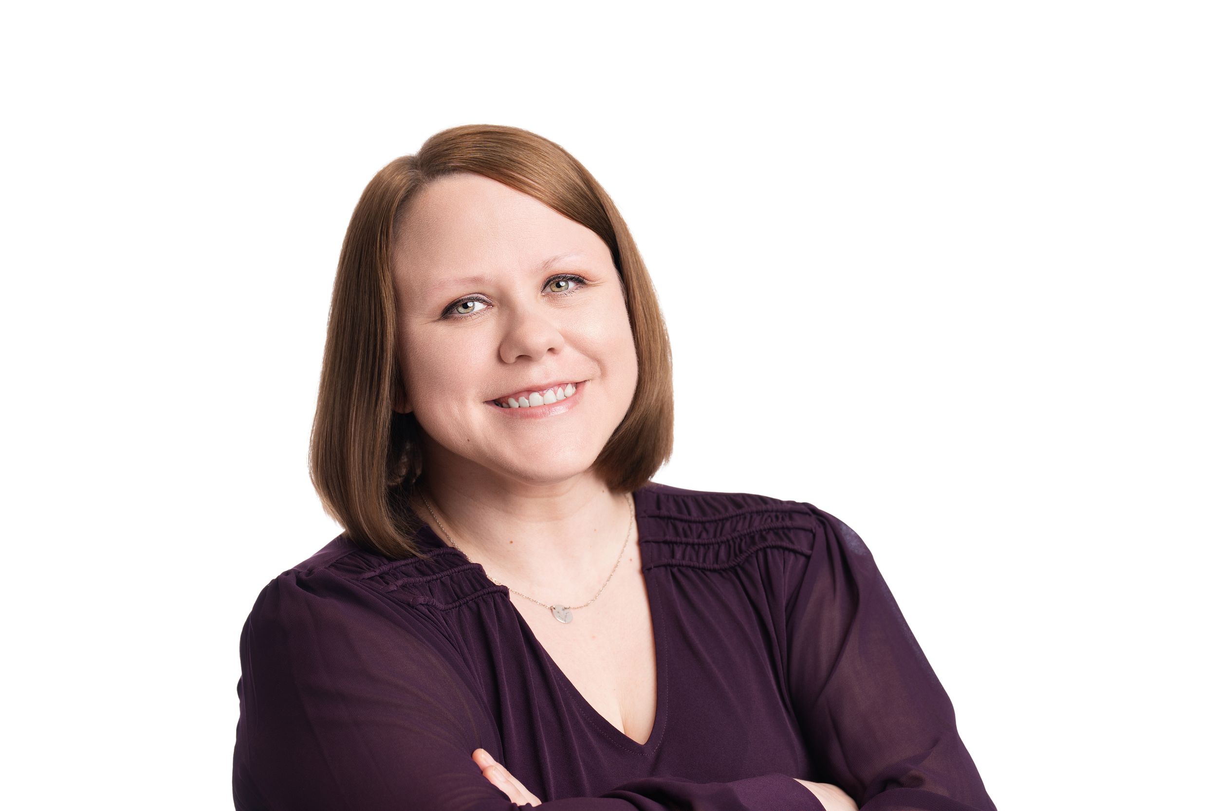A person in dark business attire posing against a light-colored background in a professional headshot.