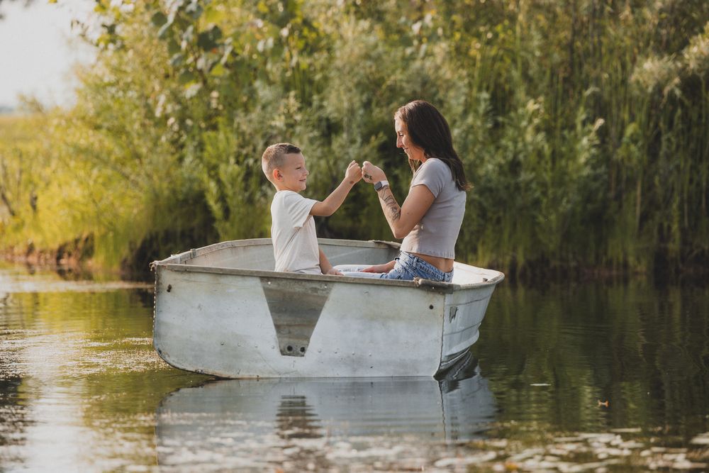 Two people share a special moment while rowing a small boat on peaceful waters.
