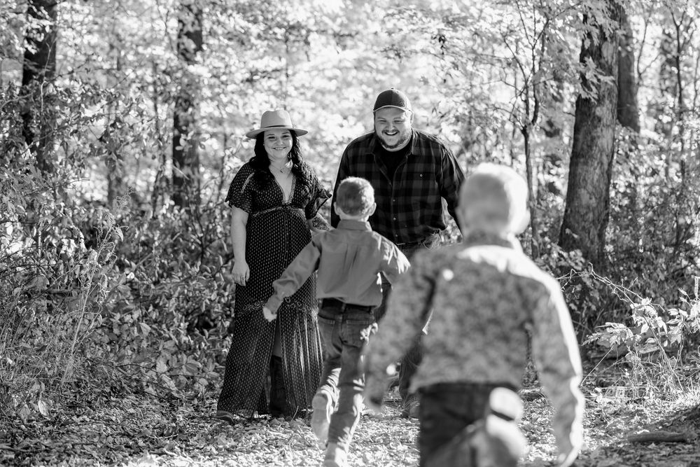 Family enjoying outdoor walk together on wooded path.