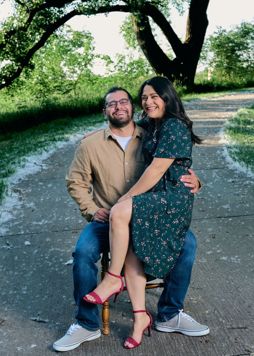 A couple sitting together on outdoor steps sharing intimate laughter and candid moments in a casual natural setting.