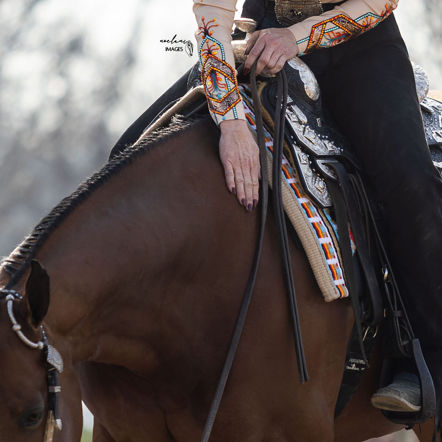Close-up rear view of a yellow horse ear with leather bridle against blurred green background.
