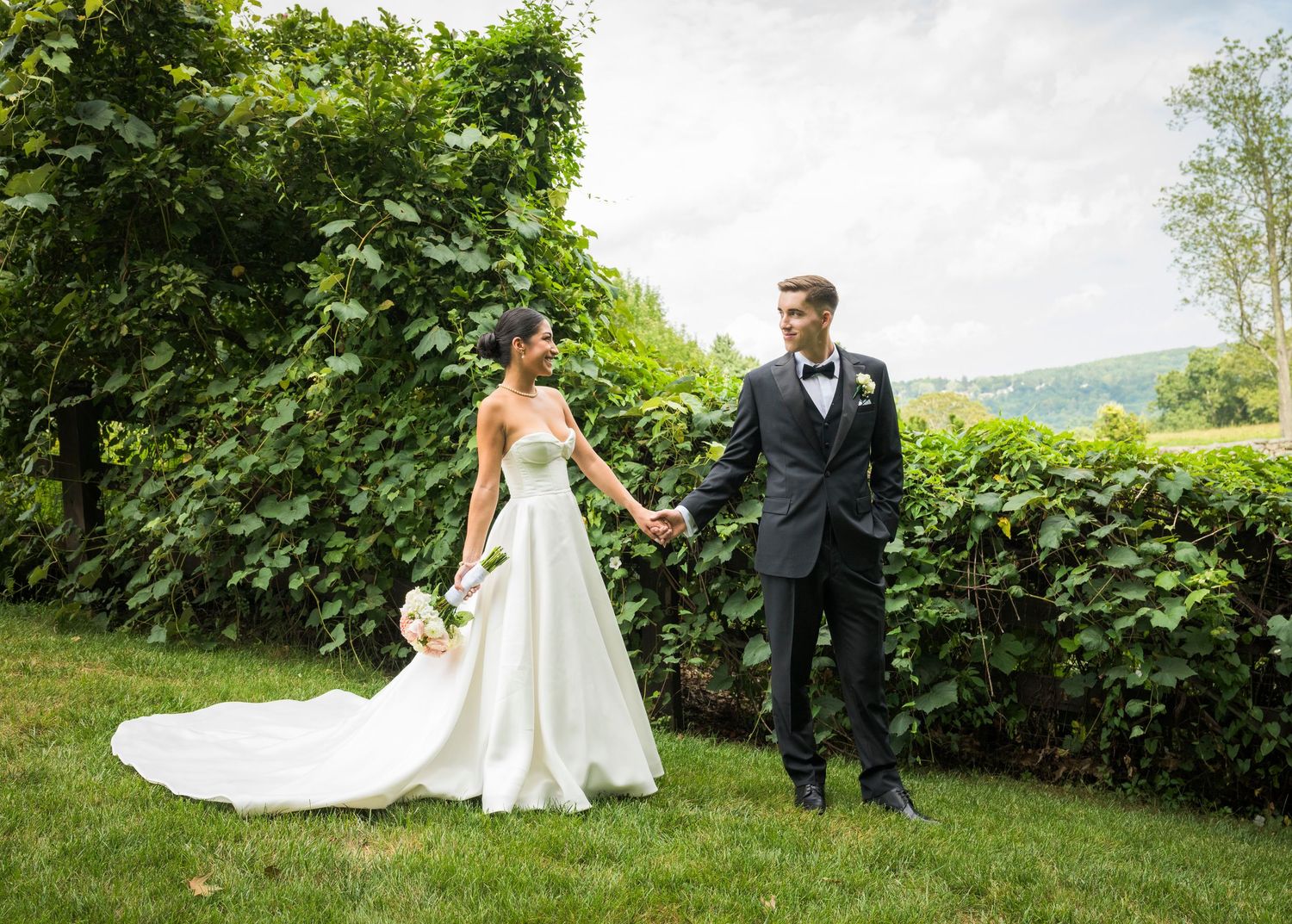 Wedding party poses in autumn setting with golden sunlight filtering through trees.