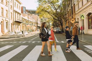 A family crossing a street at The Rocks in Sydney, evoking a modern-day "Abbey Road" scene.