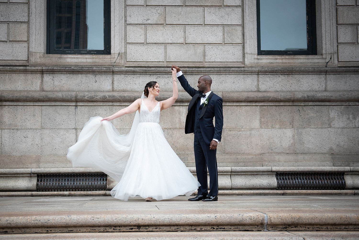 Bride and groom dancing in Copley Square Boston on the Boston Public Library steps.
