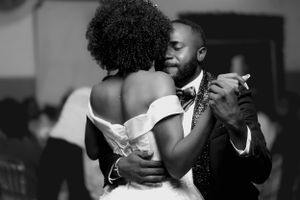 A tender moment captured in black and white as a couple shares an intimate dance at their wedding reception.