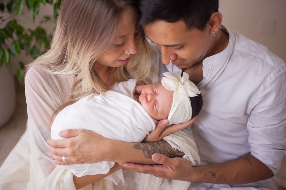 genitori con figlia baby in braccio, sessione fotografica baby a domicilio a Peschiera Borromeo, sessione baby provincia Milano, mamma papà