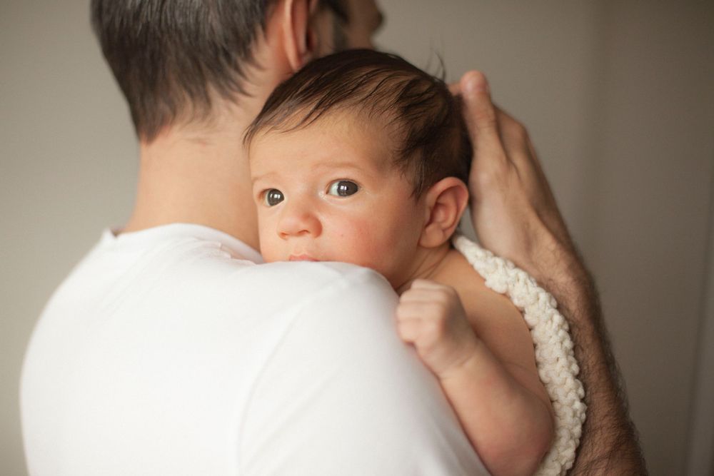 papà con figlio in braccio, sessione famiglia, sessione fotografica baby a domicilio a Peschiera Borromeo, mamma e papà abbraccio