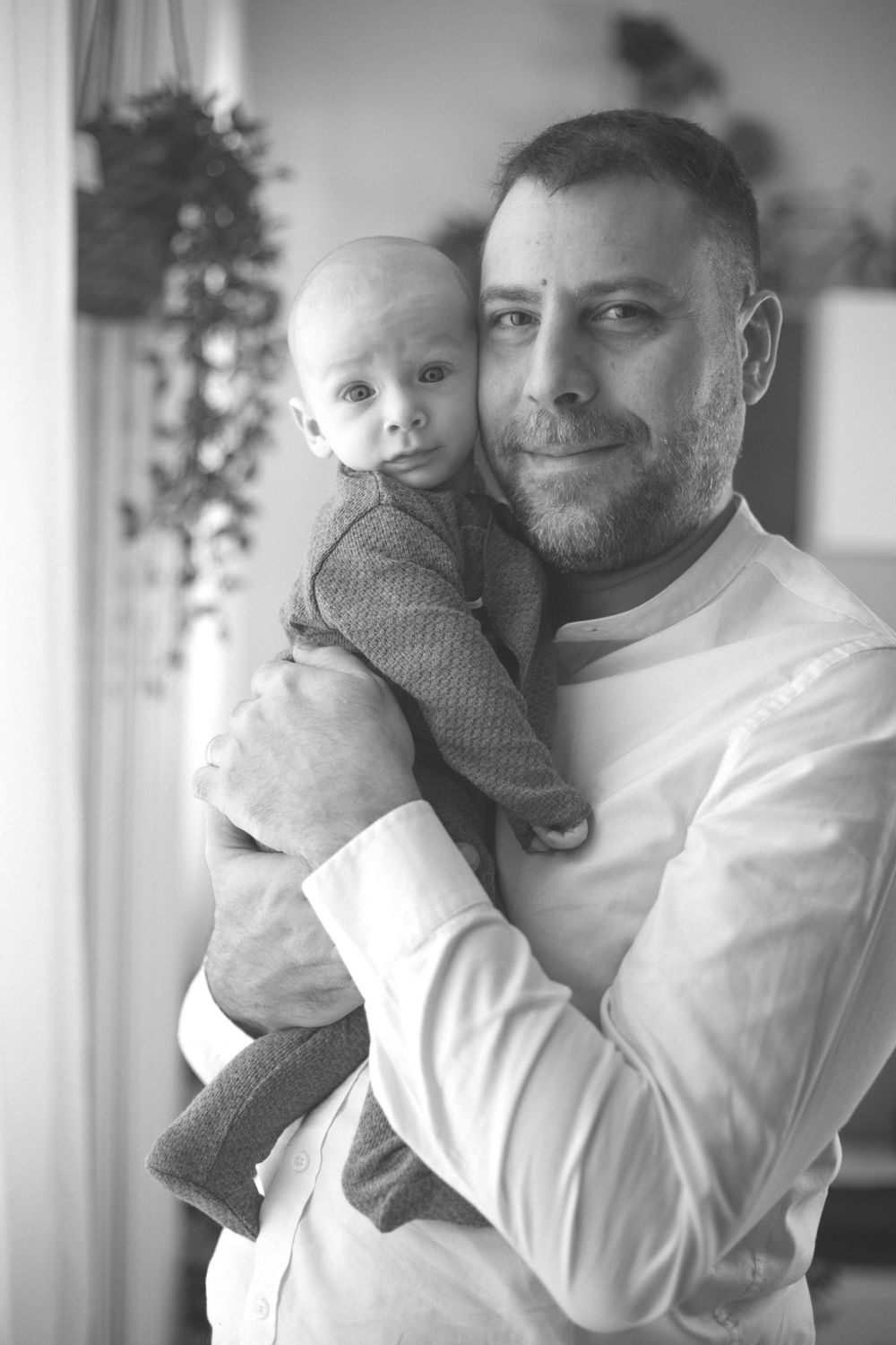 papà con in braccio suo figlio, paternità, foto bianco e nero, viso contro viso, coccole papà bimbo, neonato con papà in braccio