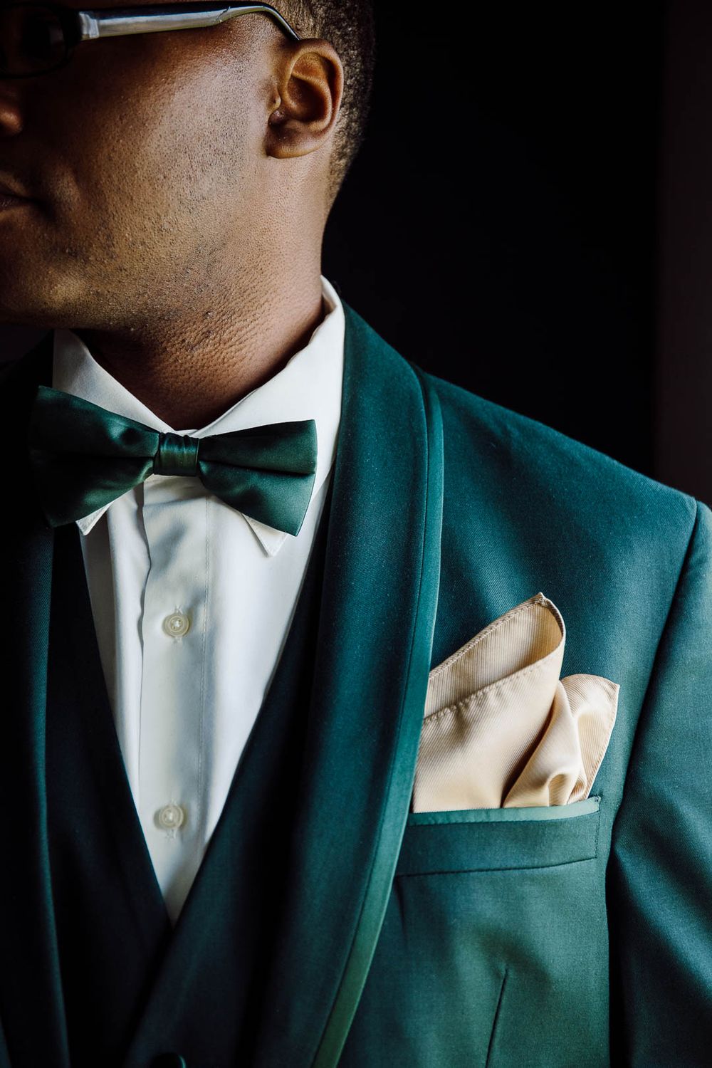 Elegant groom portrait in modern emerald tuxedo with bow tie and pocket square, captured by Cleveland wedding photographer.