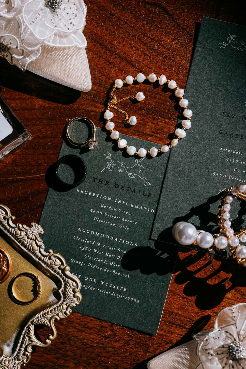 Wedding flat lay with invitations, rings, and pearls, styled details by Cleveland wedding photographer.