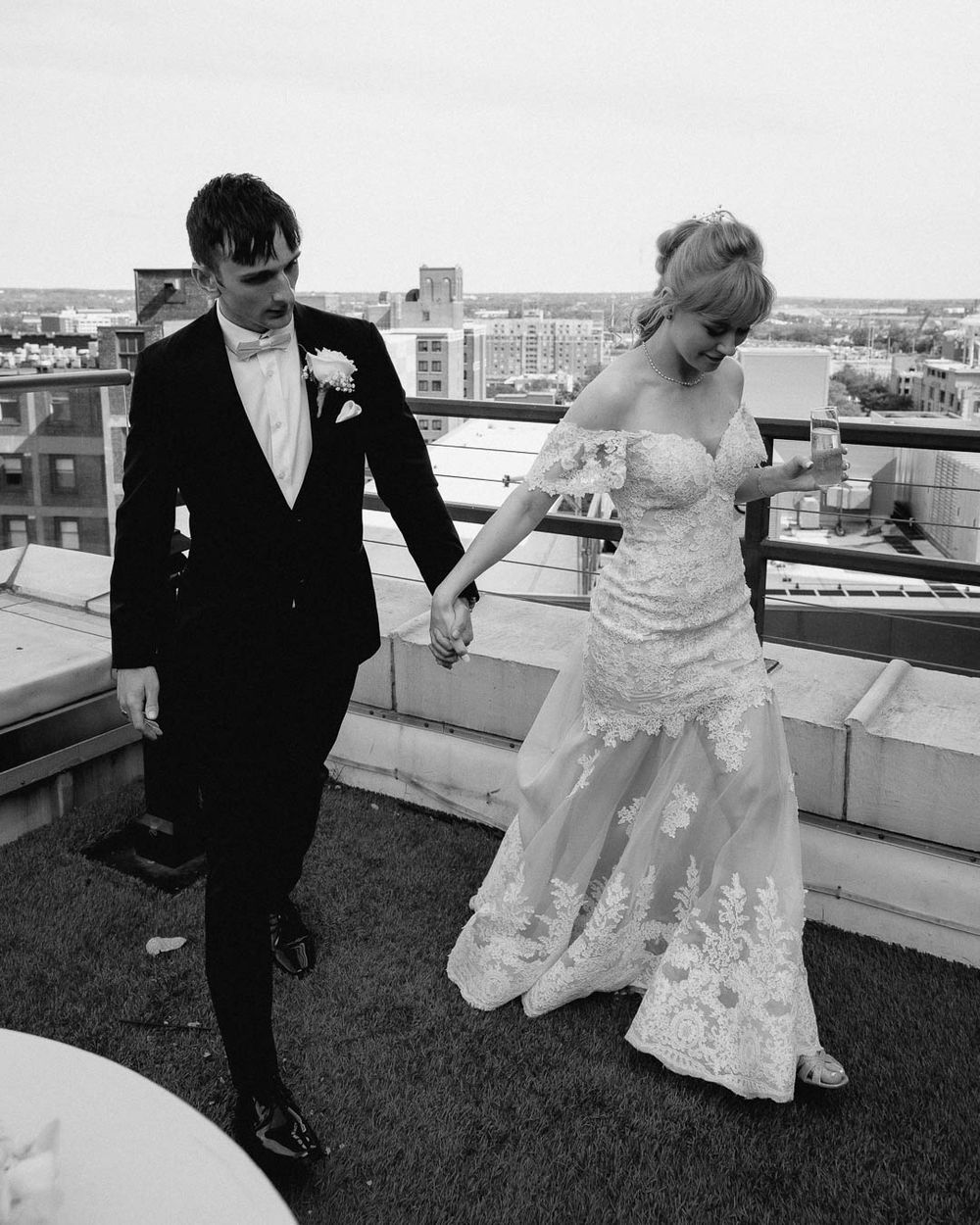 Bride and groom walking hand in hand on a Cleveland rooftop, captured by Cleveland wedding photographer.