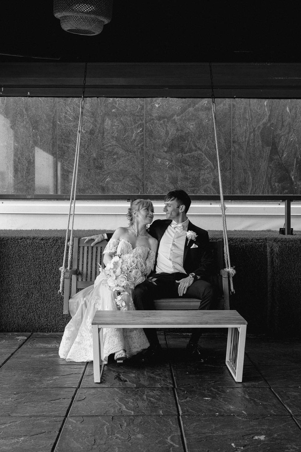Intimate black and white wedding portrait of bride and groom on a swing, captured by Cleveland wedding photographer.