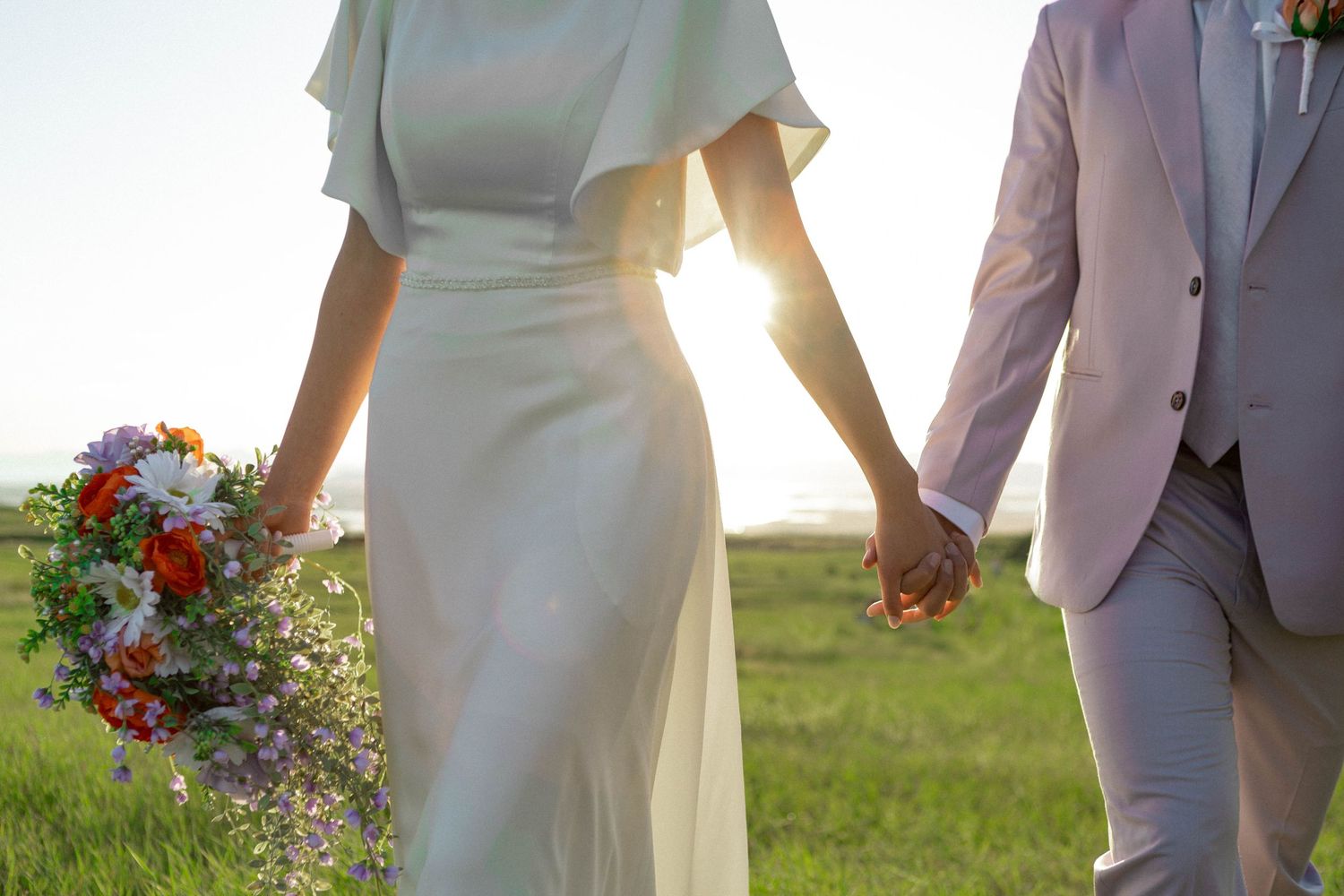 Detail shot of bouquet, dress, and suit.