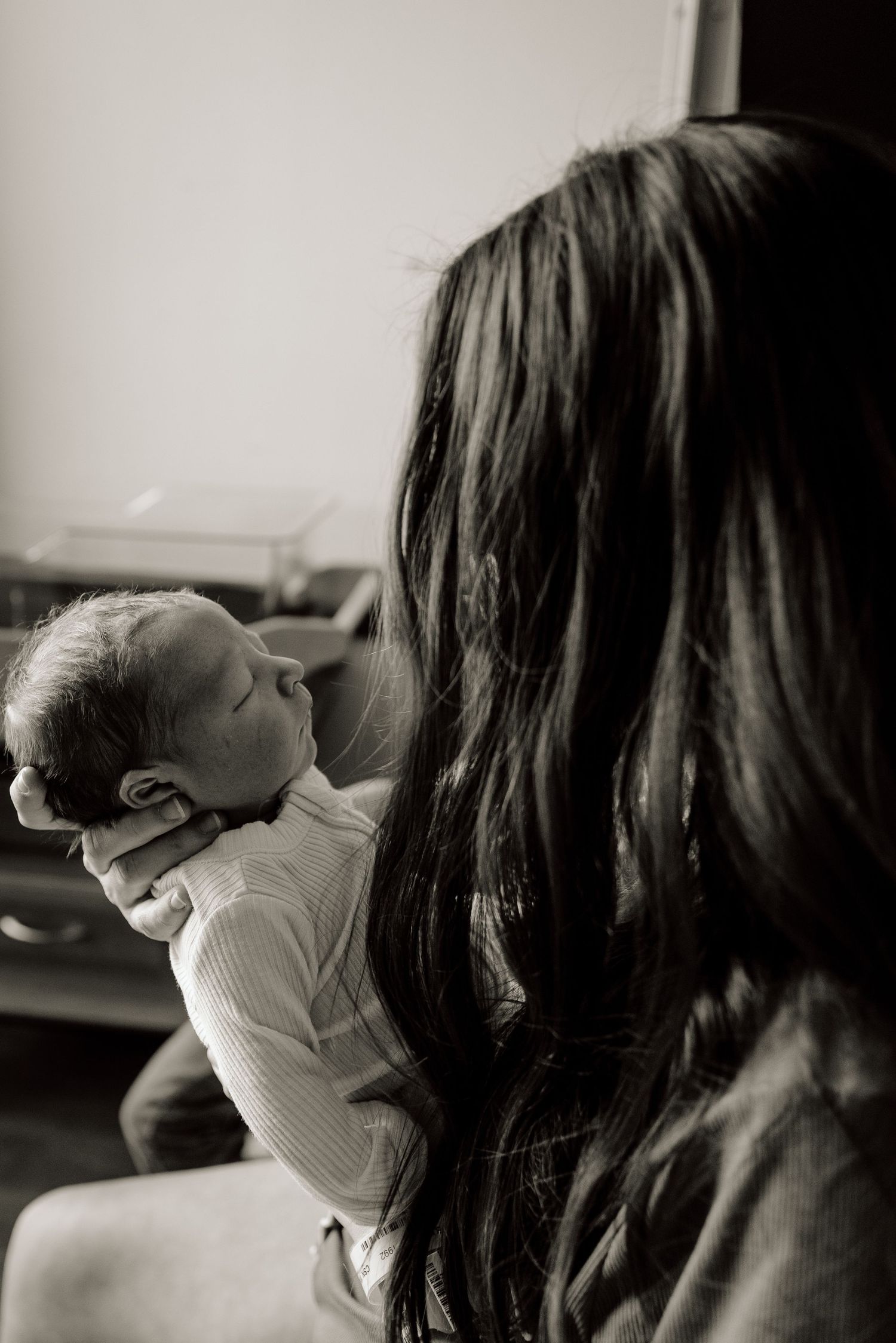 Intimate black and white portrait capturing tender moment between parent and child.