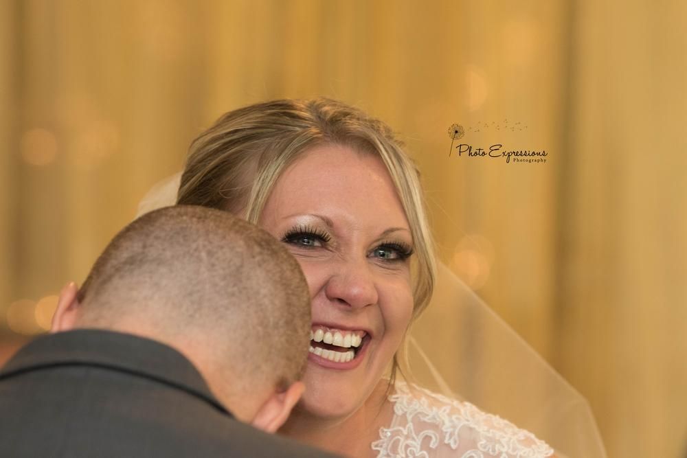 A couple laughs together during their wedding celebration indoors.