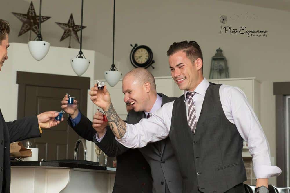 Wedding party members raise glasses in celebration during reception.