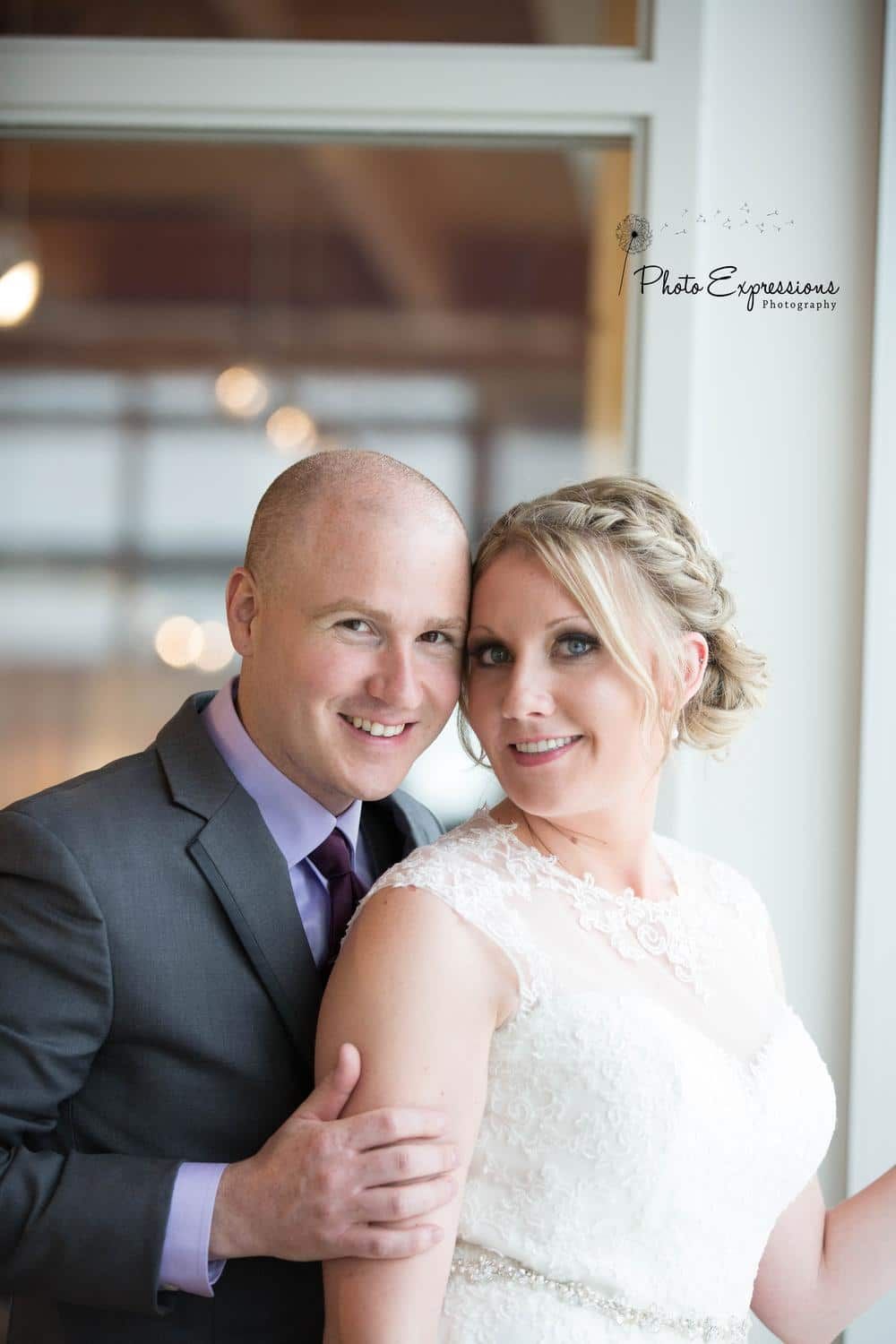 Newlyweds share tender moments during indoor wedding photo session.